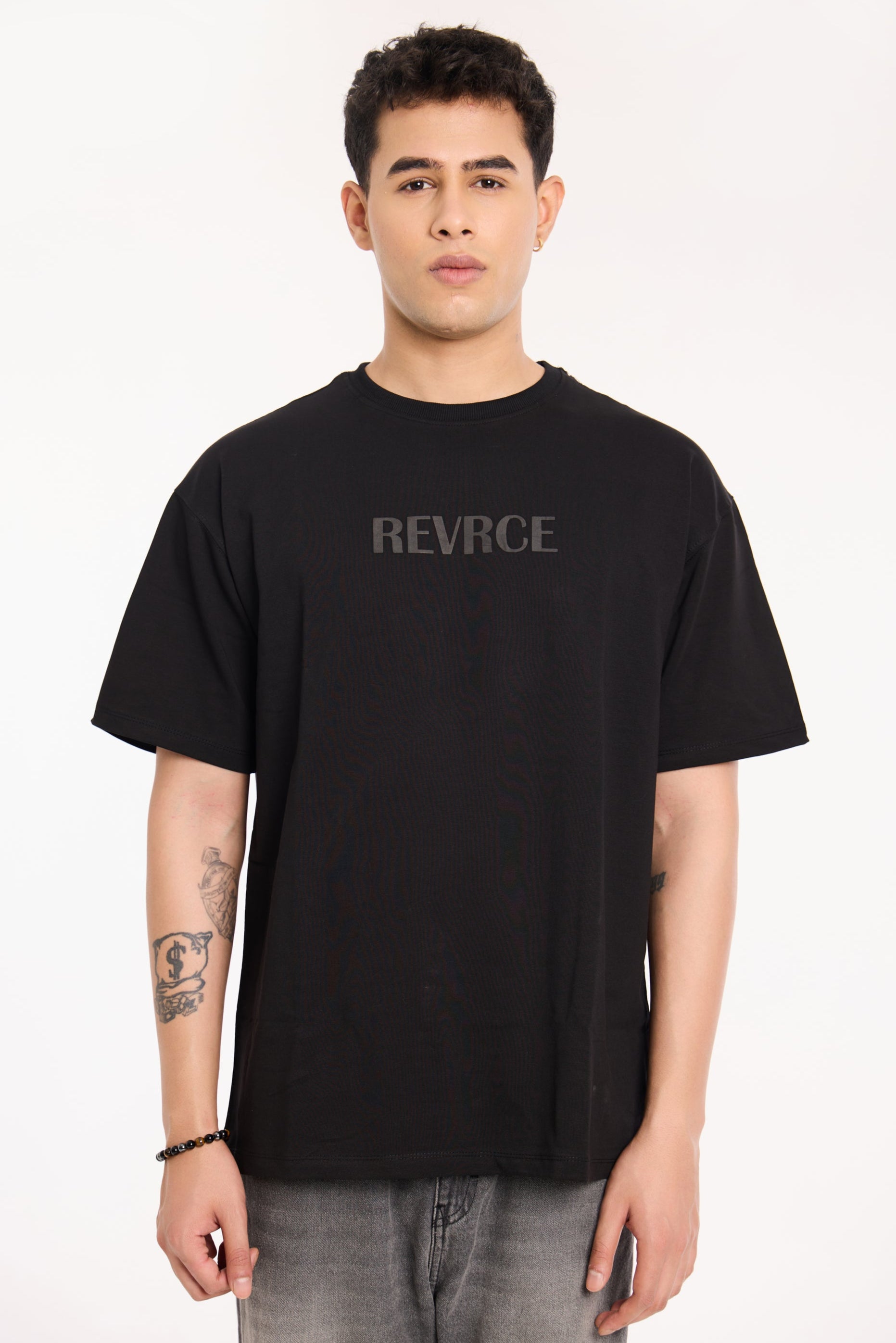 Model wearing Midnight Mark Solid Black Tee by Revrce, oversized fit streetwear T-shirt with front graphic