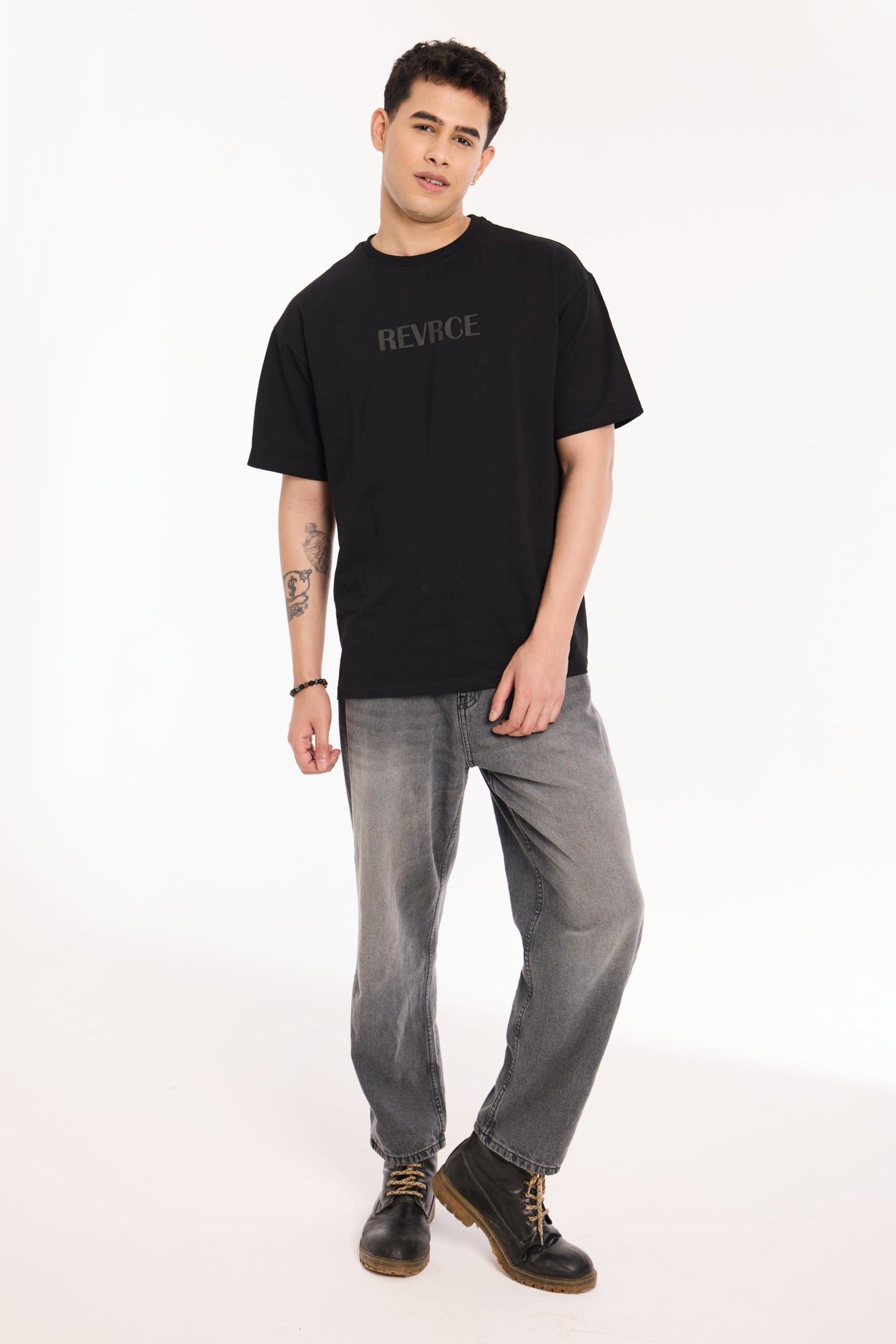 Back view of model wearing Midnight Mark Solid Black Tee by Revrce, oversized streetwear t-shirt