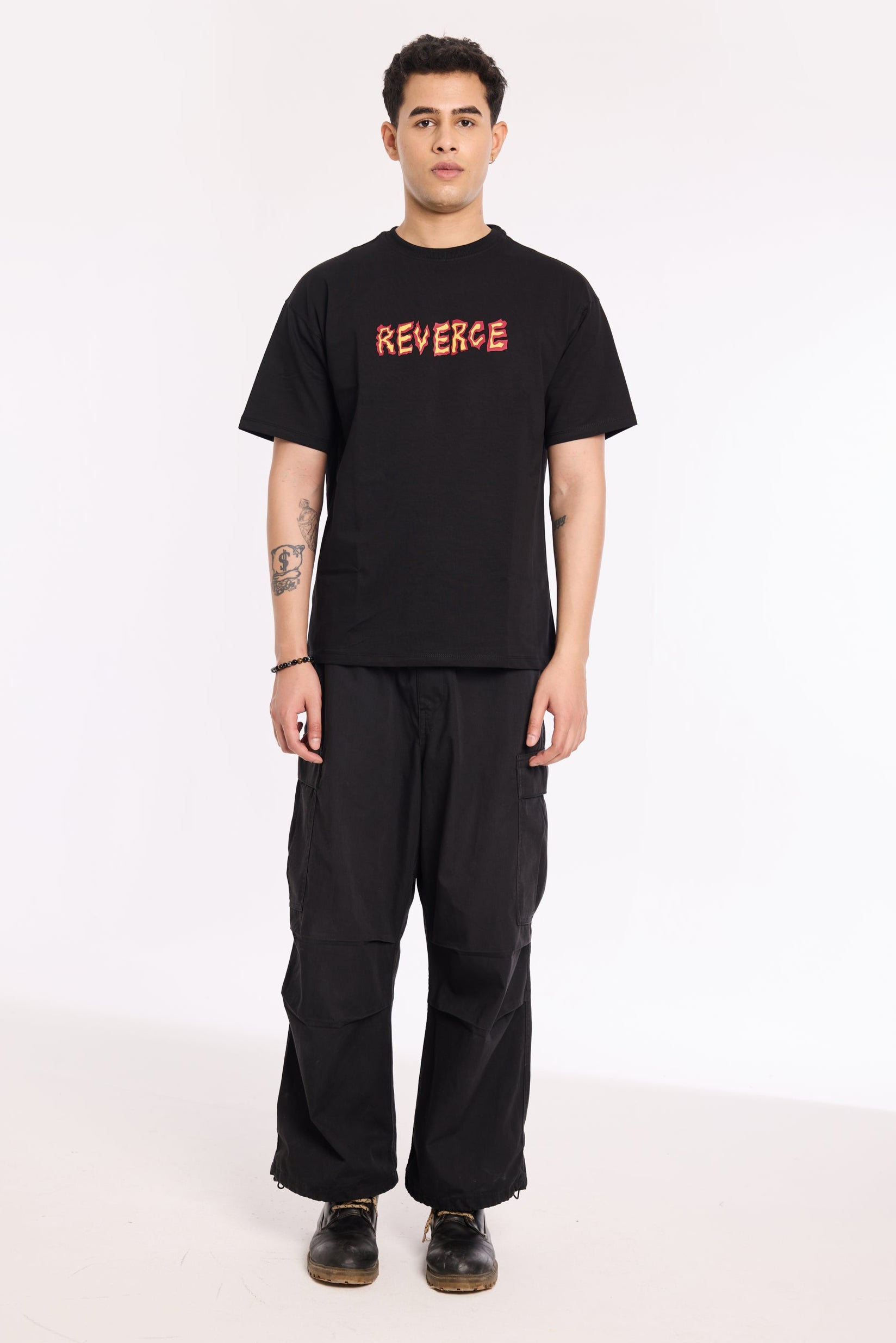 Model wearing Fired Up Black T Shirt by Revrce, oversized fit streetwear T-shirt with front graphic